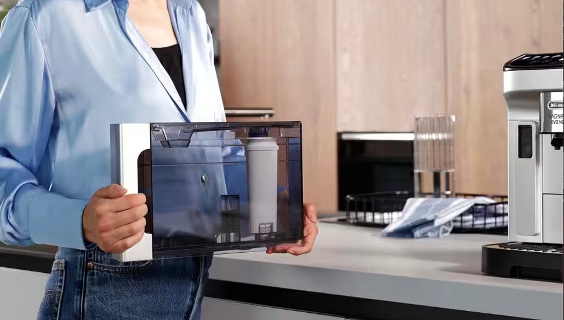 Person holding the water tank with an installed De'Longhi water filter for easy maintenance of a coffee machine, emphasizing proper coffee machine care. 
